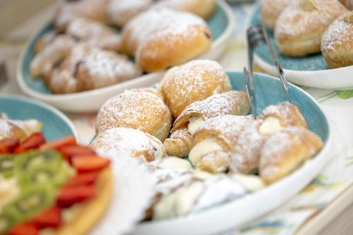 a table topped with plates of donuts and other pastries at Alaba Hotel in San Vito lo Capo