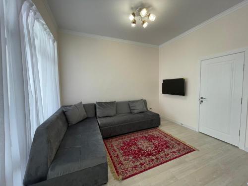 a living room with a couch and a television at Коттедж в ЦО Атлантис in Chon-Sary-Oy