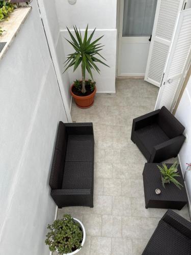 a patio with two chairs and a potted plant at Casa Myda in Bari