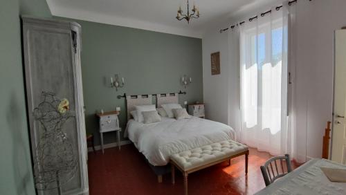 a bedroom with a white bed and a window at Les Terrasses d'Antonin in Grambois