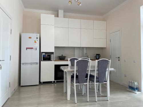 a kitchen with a table and chairs and a refrigerator at Коттедж в ЦО Атлантис in Chon-Sary-Oy