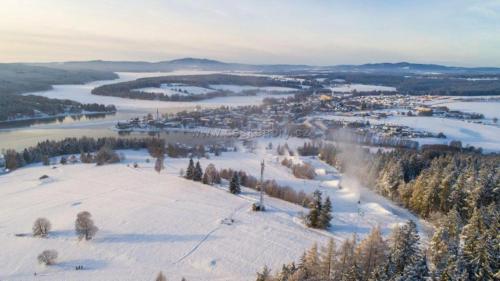 an aerial view of a snow covered hill with a town at Wellness apartmán Frymburk D403 Čtvrté patro in Frymburk