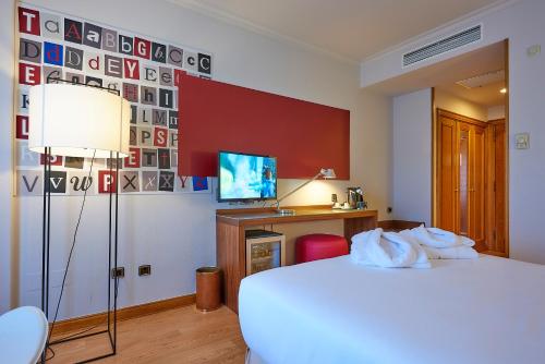 a bedroom with a bed and a desk and a television at Hotel Vigo Los Galeones Affiliated by Meliá in Vigo