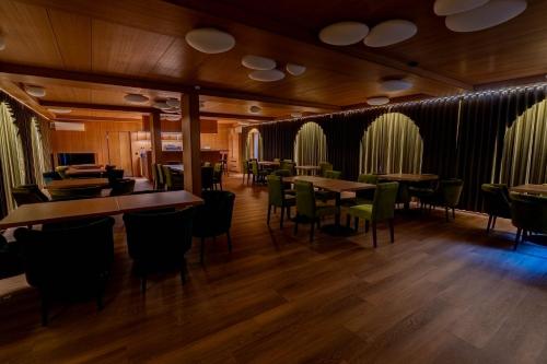 a restaurant with wooden floors and tables and chairs at Vila Misko Natos in Dovainonys III