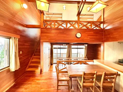 a dining room with a wooden table and chairs at マリンハウス加賀 in Matsue