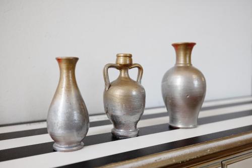 four silver vases sitting on a shelf at Locanda Casa Bardacchino in Mango