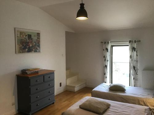 une chambre avec deux lits et une commode et une fenêtre dans l'établissement La Huppe, à Yversay