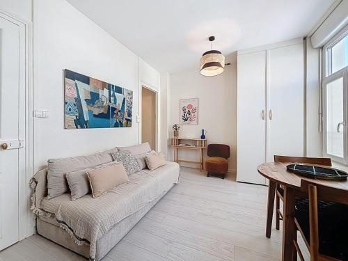 een woonkamer met een bank en een tafel bij Le Mourillon - Centre Ville in Wimereux