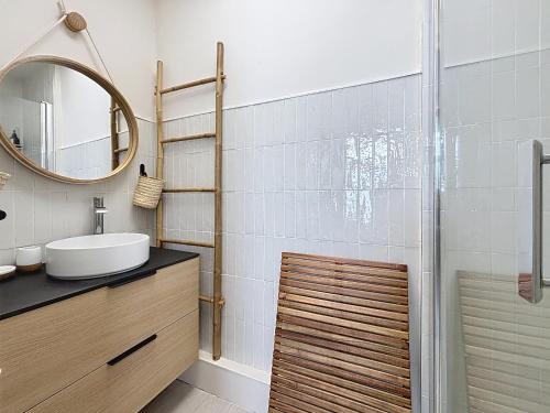 een badkamer met wastafel en douche met spiegel bij Le Mourillon - Centre Ville in Wimereux