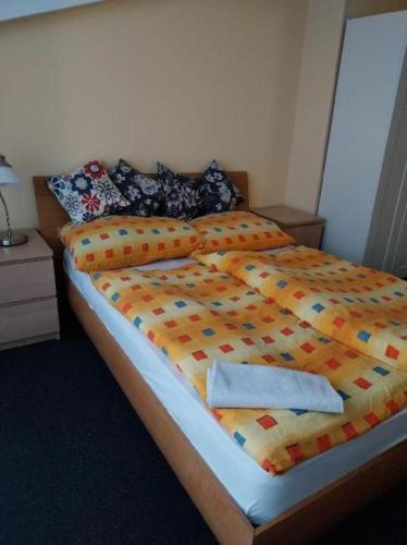 a bedroom with a large bed with colorful sheets and pillows at Wellness apartmán Frymburk D403 Čtvrté patro in Frymburk