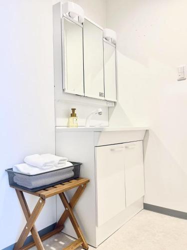 a bathroom with white cabinets and a sink at Hotel Arashi Shinsaibashi No001 in Osaka