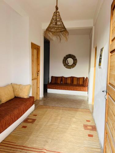 a living room with a couch and a mirror at Oceana surf house in Imsouane