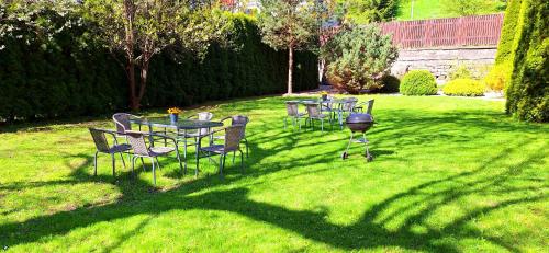 a group of tables and chairs on a lawn at Apartmány Paseky - Jablonec nad Nisou in Jablonec nad Nisou