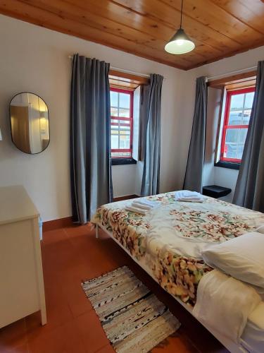 a bedroom with a bed with blue curtains at Quinta do Atlântico in Biscoitos