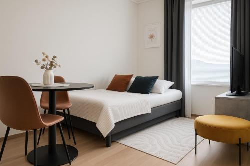 a bedroom with a bed and a table and chairs at Tammer Huoneistot - City Suite 6 - Best Location & Great Amenities in Tampere