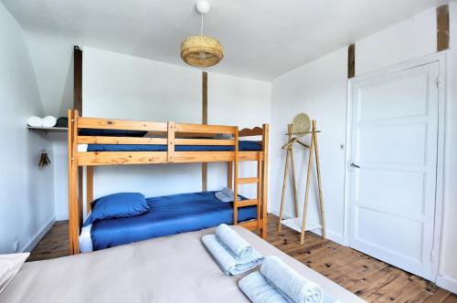 a bedroom with a bunk bed with blue pillows at Maison 6 personnes à 2 pas du Canal de Nantes à Brest in Carhaix-Plouguer