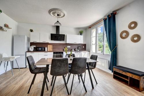 a kitchen and dining room with a table and chairs at Maison 6 personnes à 2 pas du Canal de Nantes à Brest in Carhaix-Plouguer