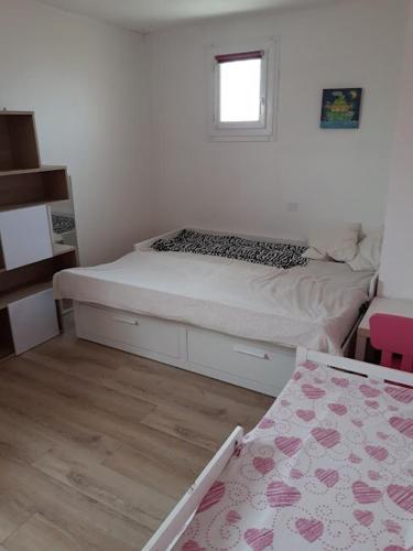 une petite chambre avec un lit et une fenêtre dans l'établissement Maison provençale avec une grande piscine, à Garons