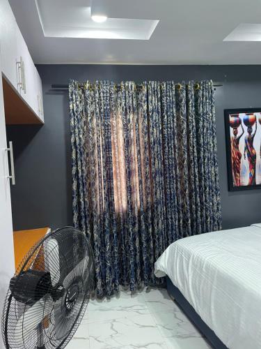 a bedroom with a fan next to a bed at Umbrella Properties hotels and apartments - Moniya in Ibadan