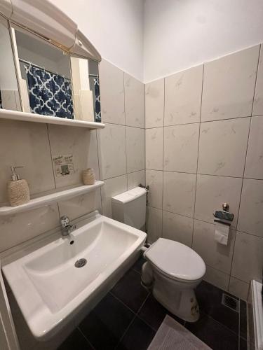 a white bathroom with a sink and a toilet at Bach's Restaurant Bar Hotel in Erkrath