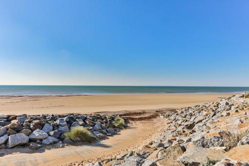 une plage avec des rochers et l'océan en arrière-plan dans l'établissement Un Air de Vacances - À 2 pas de la mer, à Saint-Hilaire-de-Riez