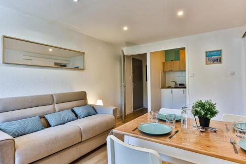 un salon avec un canapé et une table dans l'établissement Un Air de Vacances - À 2 pas de la mer, à Saint-Hilaire-de-Riez