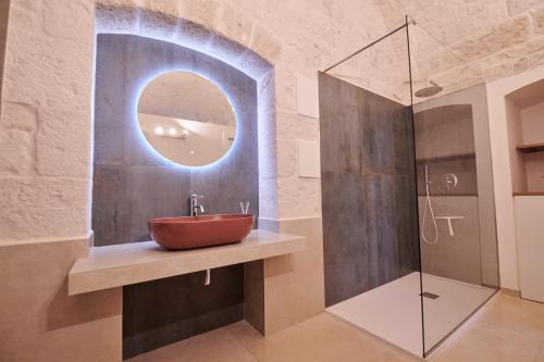 a bathroom with a red sink and a mirror at Domus Villanova in Triggianello