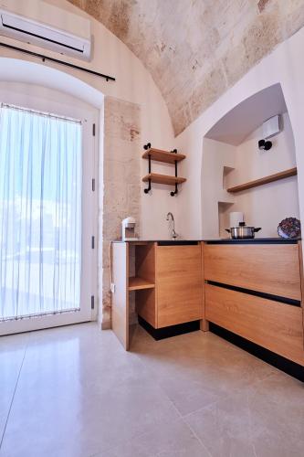 a kitchen with a wooden counter and a window at Domus Villanova in Triggianello