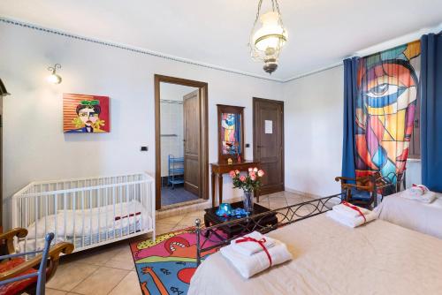 a bedroom with two beds and a crib and a mirror at Locanda Casa Bardacchino in Mango
