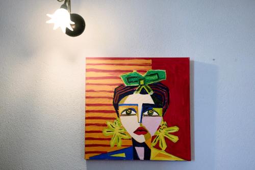 a painting of a woman with a green bow on her head at Locanda Casa Bardacchino in Mango