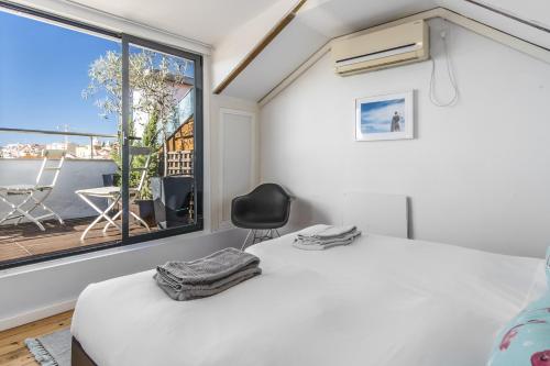 a bedroom with a bed and a window and a chair at LV Premier Apartments P.Real- PI in Lisbon