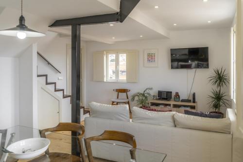 a living room with a white couch and some chairs at LV Premier Apartments P.Real- PI in Lisbon