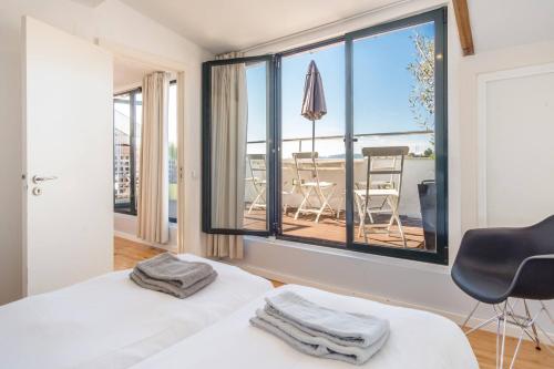 a bedroom with two beds and a large window at LV Premier Apartments P.Real- PI in Lisbon