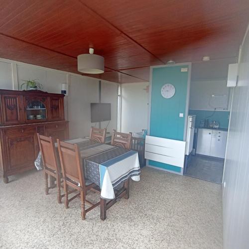 une cuisine et une salle à manger avec une table et des chaises dans l'établissement Chalet Lestraouen, à Plougastel-Daoulas
