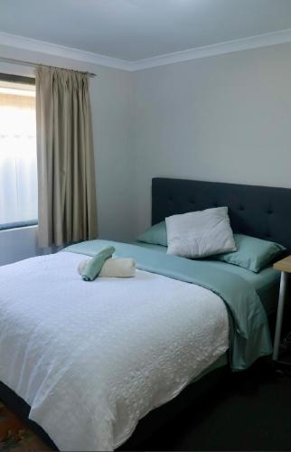 a bedroom with a large bed with a blue headboard at Home Sweet Perth in Perth
