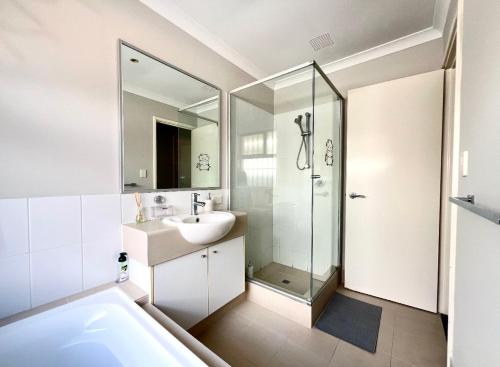 a white bathroom with a sink and a shower at Home Sweet Perth in Perth