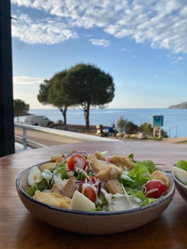 une salade dans un bol sur une table avec vue dans l'établissement Hotel Restaurant Le Filosorma, à Galéria