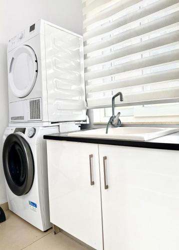 a kitchen with a washing machine and a sink at Charming 3-Bedroom House of Character - Perfect Family Retreat - Naxxar in Il-Gwejdi