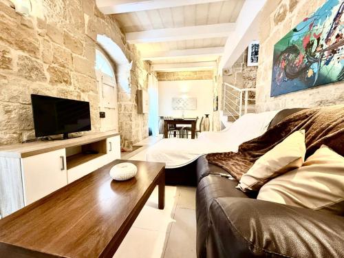 a living room with a couch and a tv at Charming 3-Bedroom House of Character - Perfect Family Retreat - Naxxar in Il-Gwejdi