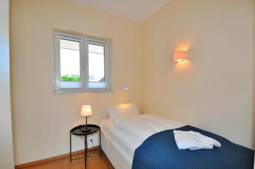 a bedroom with a bed and a window at Appartement Penthouse in St. Peter-Ording
