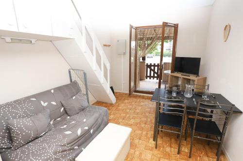 un salon avec un canapé et une table dans l'établissement Petite maison avec terrasse en bord de plage, à Saint-Cyprien