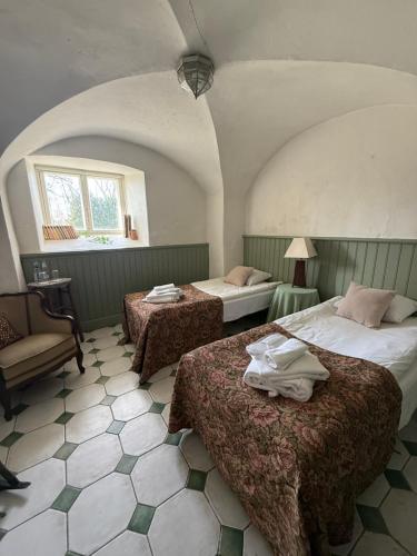 a bedroom with two beds and a chair and a window at Laitse castle in Laitse