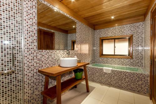a bathroom with a sink and a bath tub at Angkor Heart Bungalow in Siem Reap
