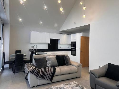 a living room with a couch and a kitchen at Apple Tree House in Stifford