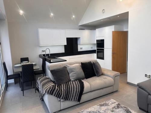 a living room with a couch and a kitchen at Apple Tree House in Stifford