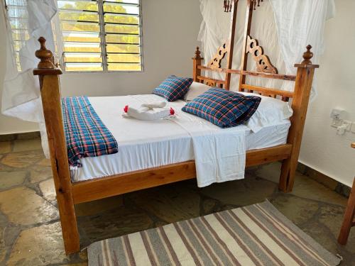 a wooden bed with a bird sitting on top of it at Villa Verona Watamu in Watamu