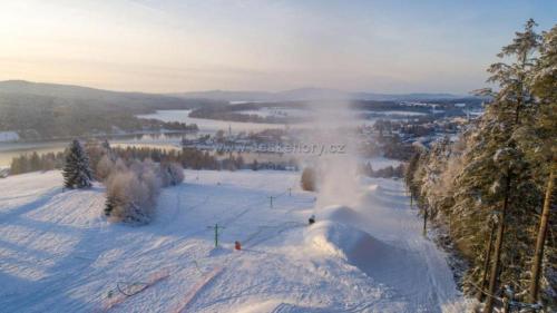 a group of people skiing down a snow covered slope at Wellness apartmán Frymburk D403 Čtvrté patro in Frymburk