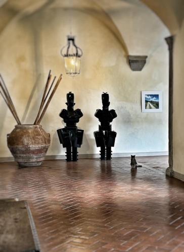 a room with two statues and a cat on the floor at Badia a Coltibuono Wine Resort in Gaiole in Chianti