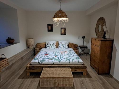 a bedroom with a large bed and a chandelier at La Clef des songes in Lafarre