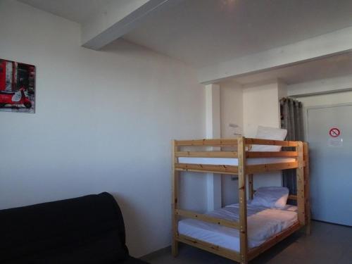 Ce lit superposé se trouve dans un dortoir doté d'un canapé. dans l'établissement Studio cosy 4 pers, ski aux pieds, casier à skis, parkings gratuits, équipement complet inclus. - FR-1-602-4, à Arette